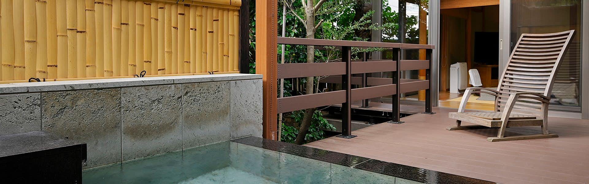 Atami Onsen Sanpeiso with this scene, where a private open-air bath adjoins a timber deck and secluded green garden.