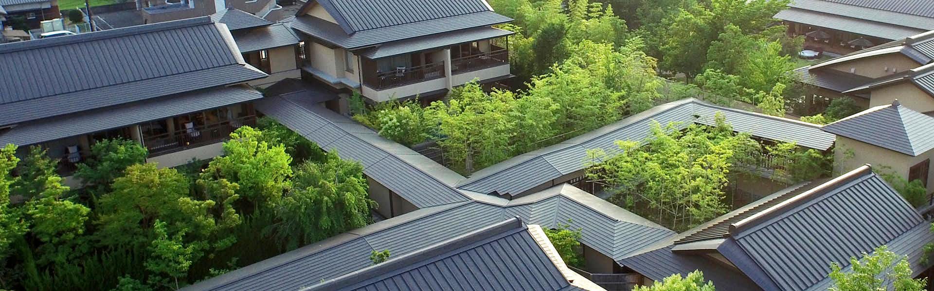 Yamaguchi Yuda Onsen Koki-an Angular metal roof planes with rectangular skylights and intersecting surfaces surrounded by dense trees