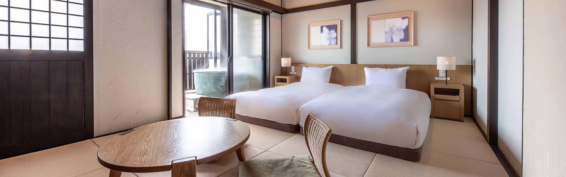 Bisei: Inn with a View of Mount Yufu with a bright twin bedroom with small sitting area.