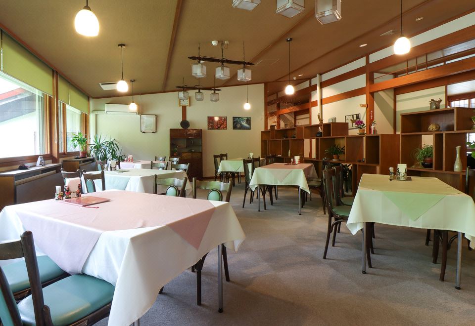 A dining room with tablecloth-covered tables.