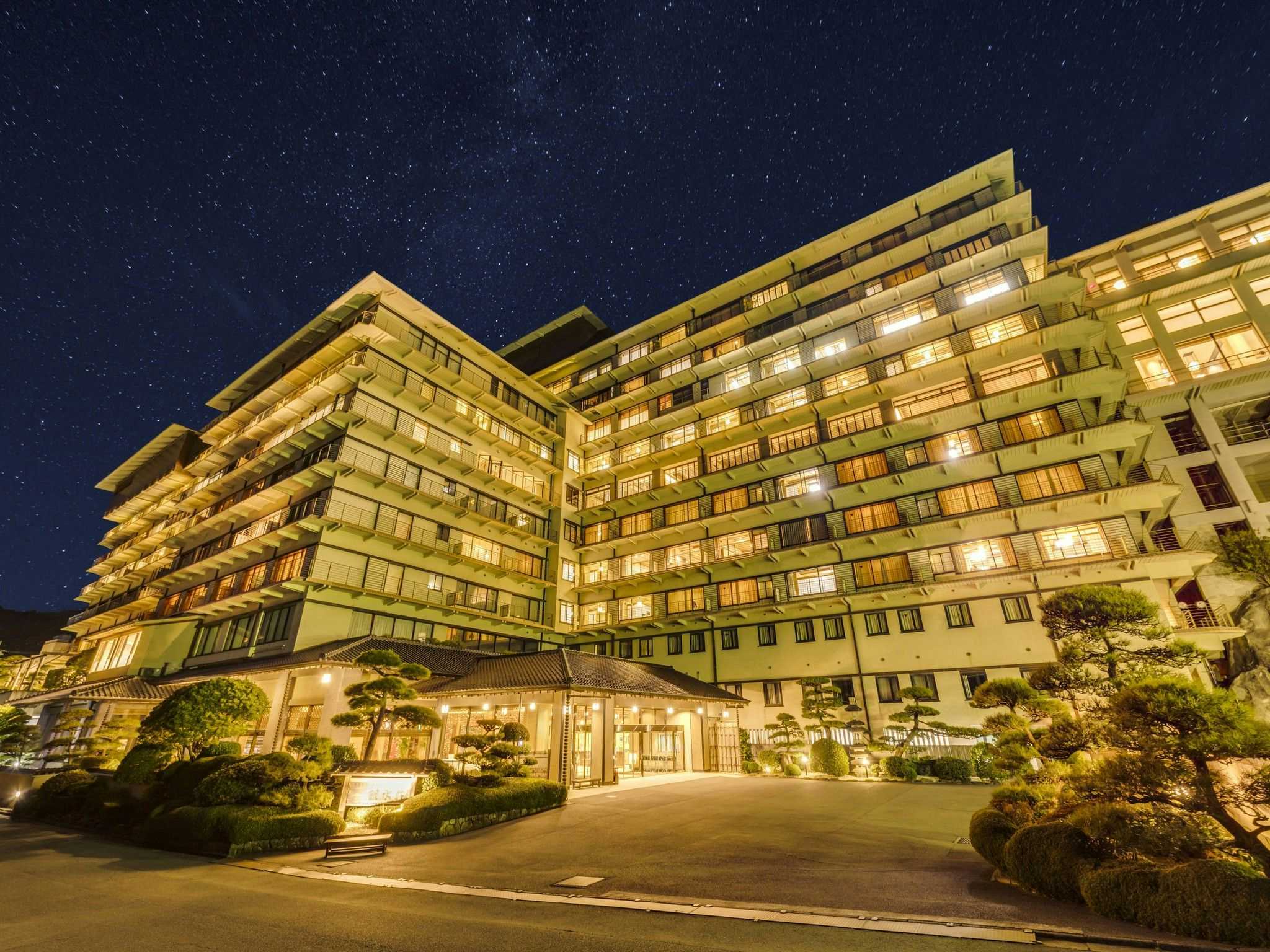 The large coastal hotel illuminated beneath a starry night sky.