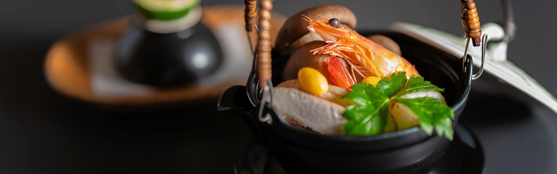 Gensen-yu no Yado Shisuitei with a seasonal seafood dish presented inside dark lacquerware.