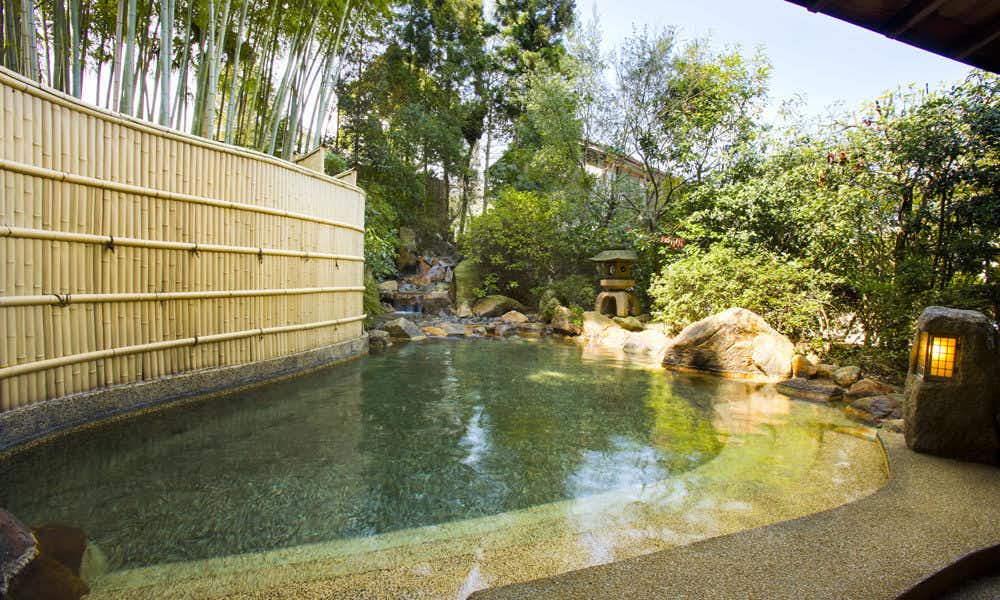 Ryotei Yamanoi with an open-air garden bath surrounded by bamboo fencing.
