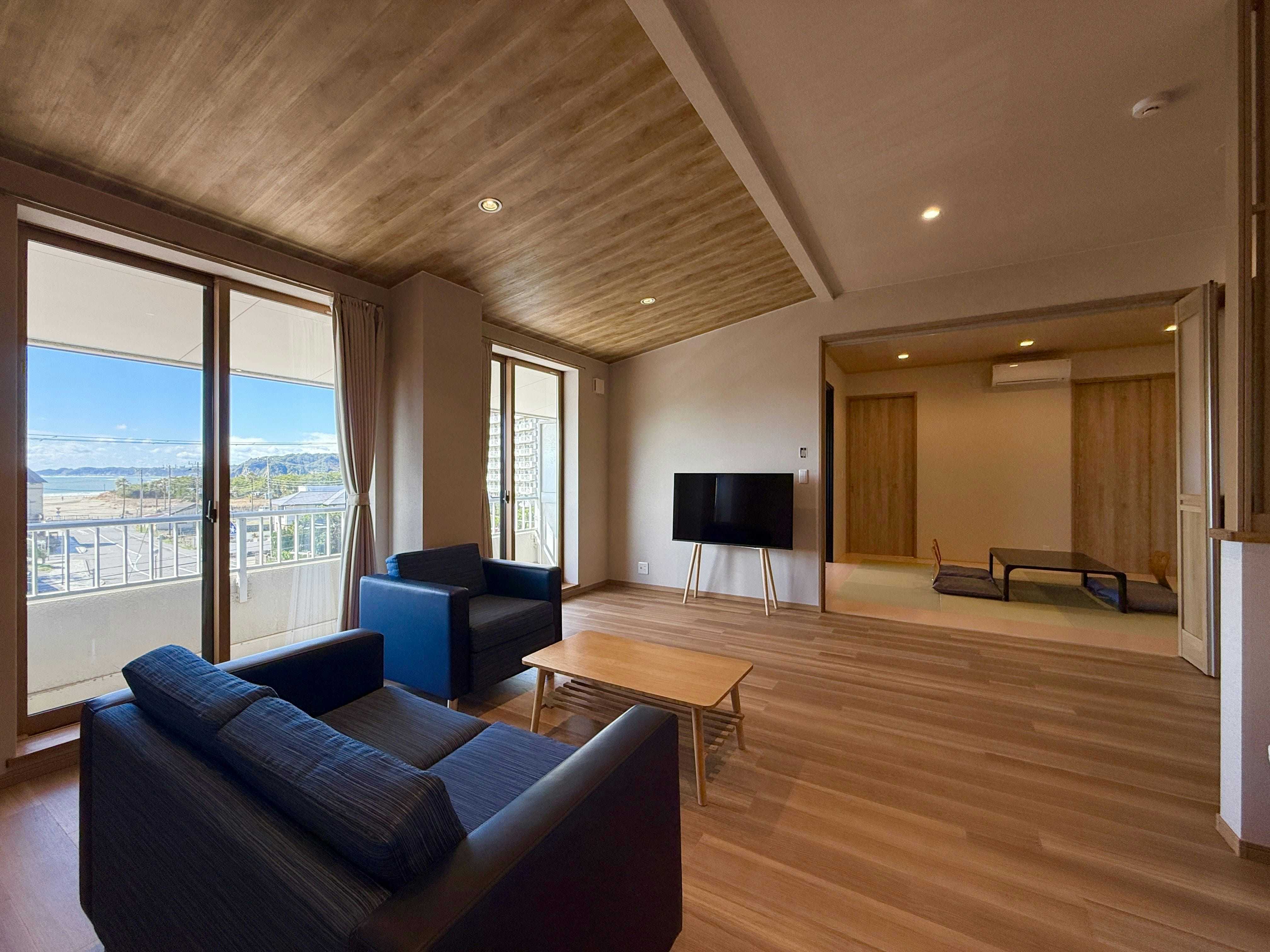 Onjuku Onsen Ise Ebi & Awabi Specialty Inn Ohno-so with a modern lounge with blue sofas and coastal windows.