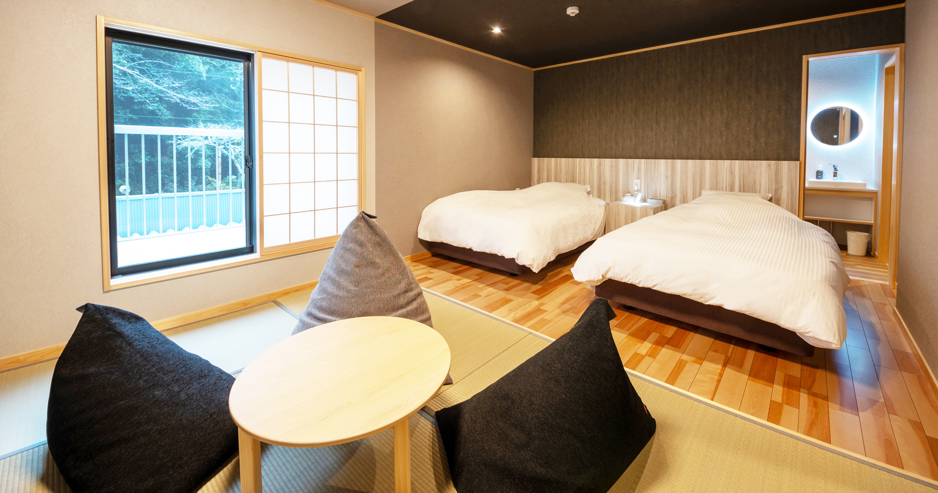 A twin room with a round table and window view.