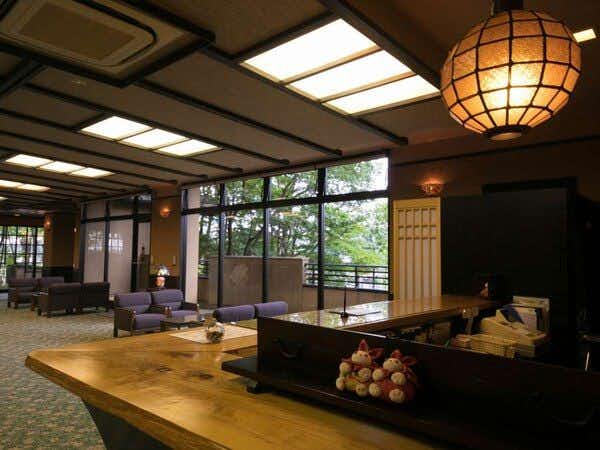 Yunosato Hayama with a welcoming lobby with low seating and patterned timber screens.