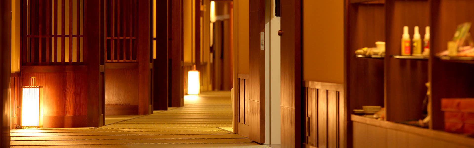 Otaru Kourakuen with a warmly lit corridor lined with wooden lattice screens.