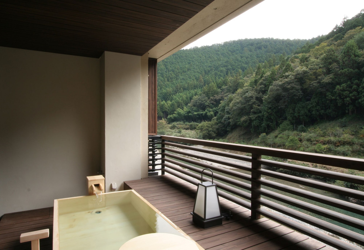 A broad balcony overlooks a forested valley.