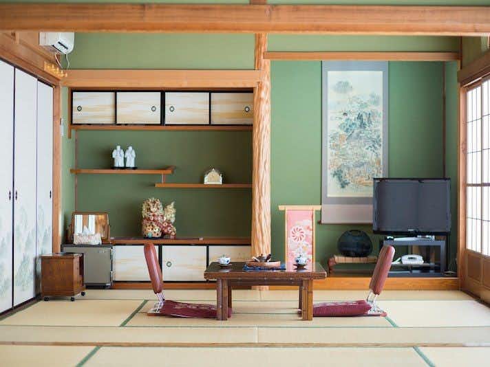 Ryokan Kuboji with a green tatami guest room with low table and alcove.