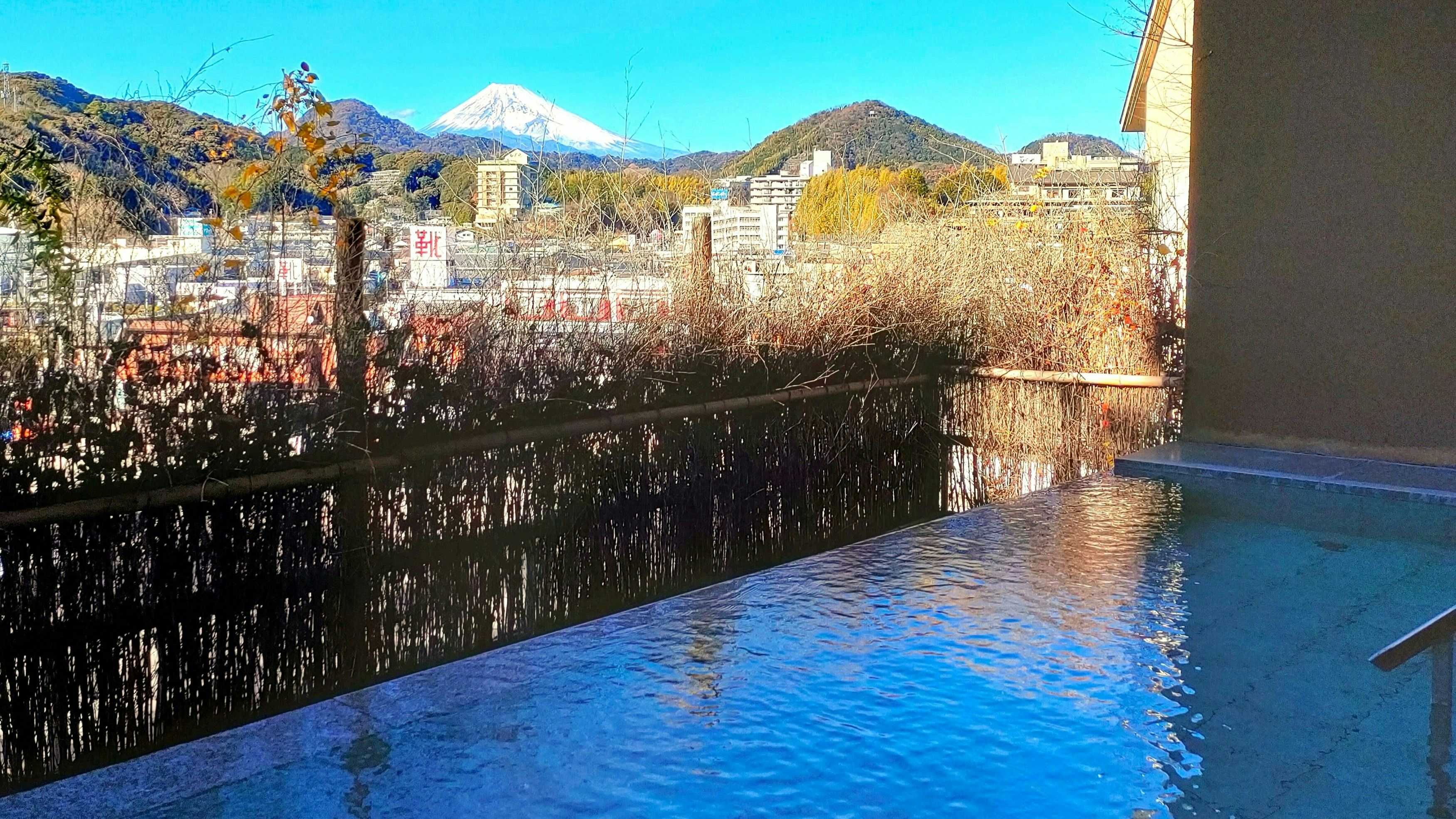 Kameya Ean with a blue infinity bath overlooking town rooftops and Mount Fuji.