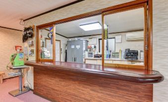 A wooden reception counter with sliding glass windows.