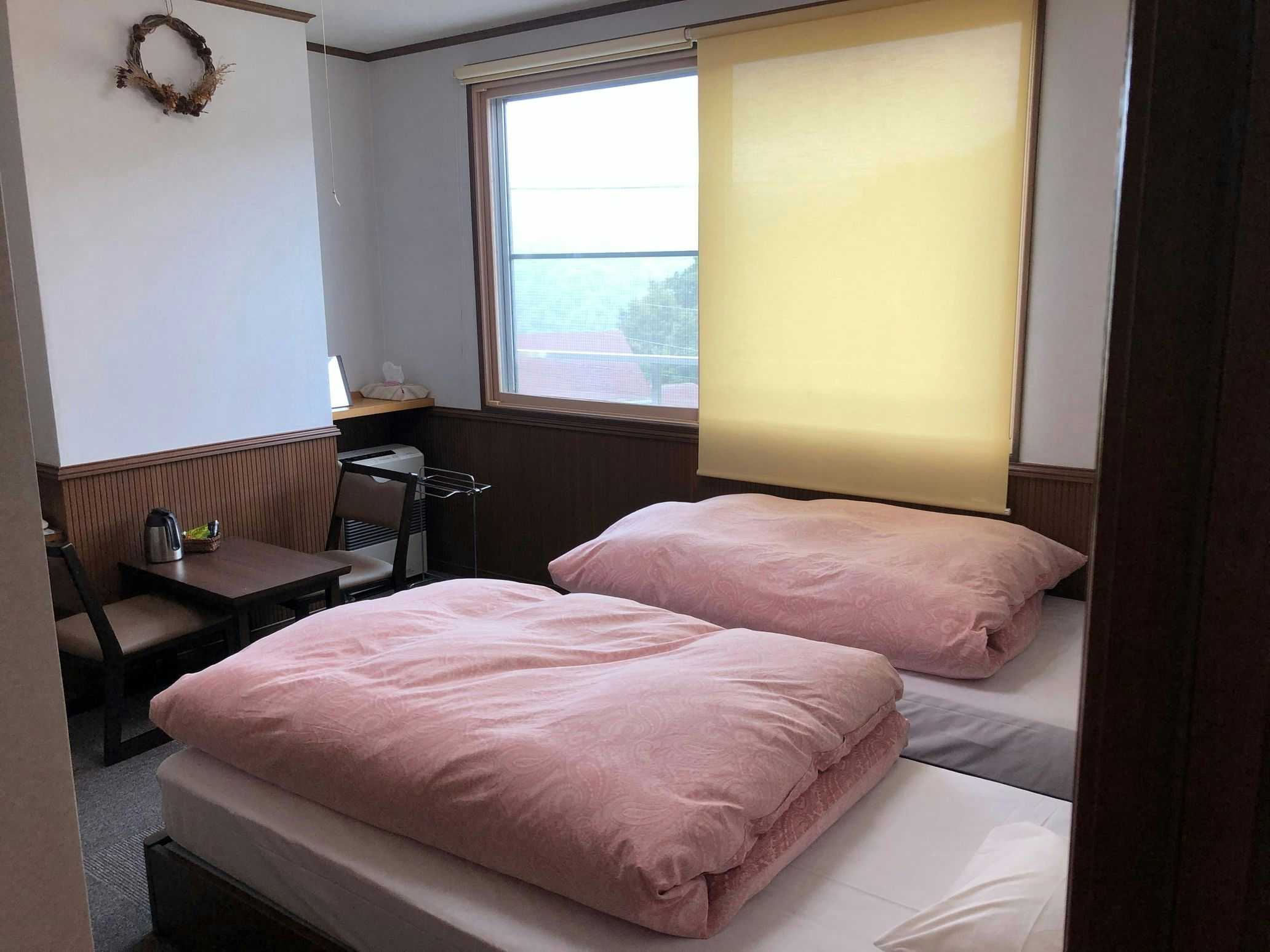Gassan Inn Kashiwaya with a simple guest room prepared with two pink floor futons.