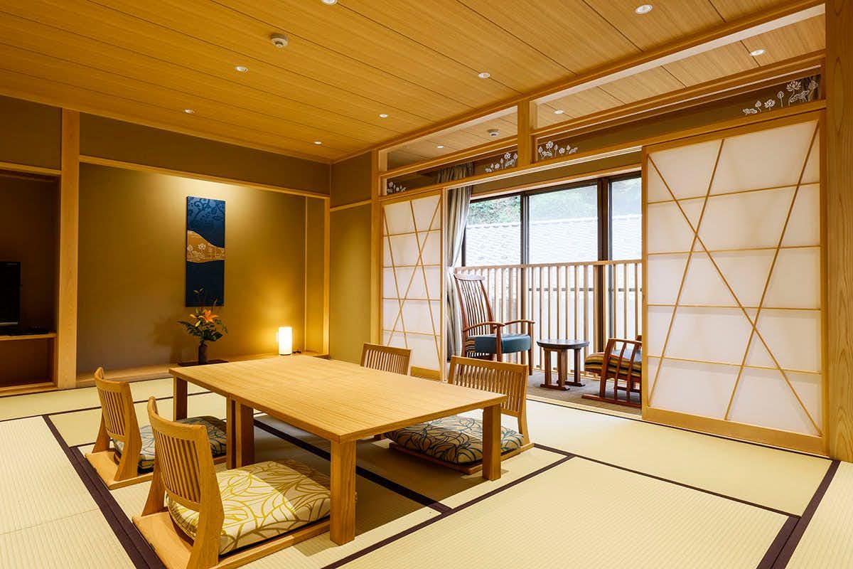 Yuraku Kinosaki Spa & Gardens a tatami room with a low table and geometric shoji screens.
