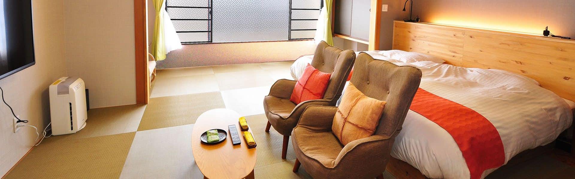 Yumoto Itaya with a comfortable twin room with red bedding and massage chairs.