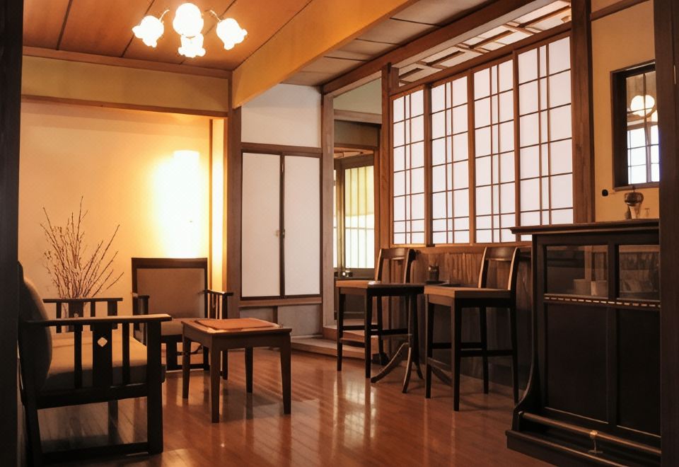 A warmly lit ryokan dining room opens beside a small garden.