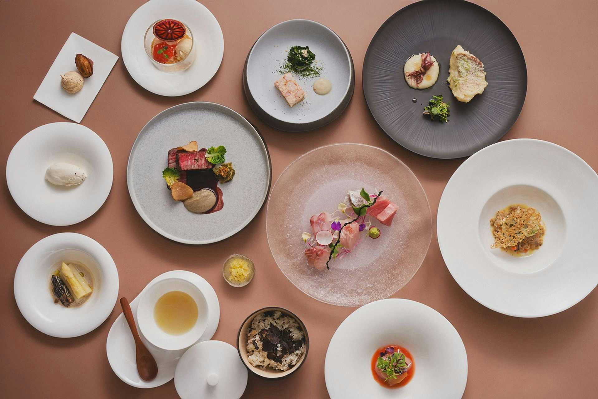 Albergo Yuraku with an overhead tasting menu arranged across white and gray plates.