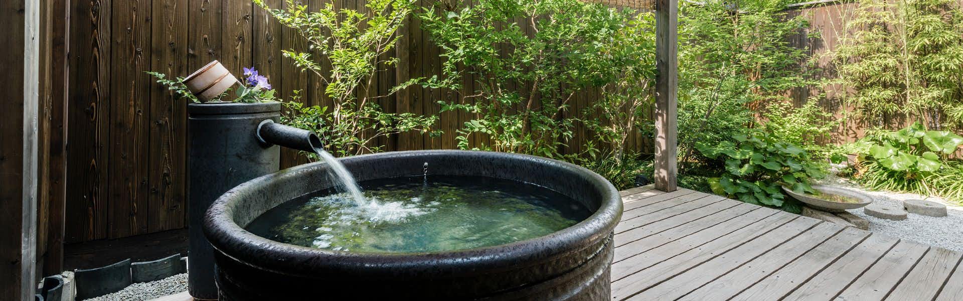 Nazuna Kyoto Nijo-jo with a round outdoor tub on a secluded garden terrace.