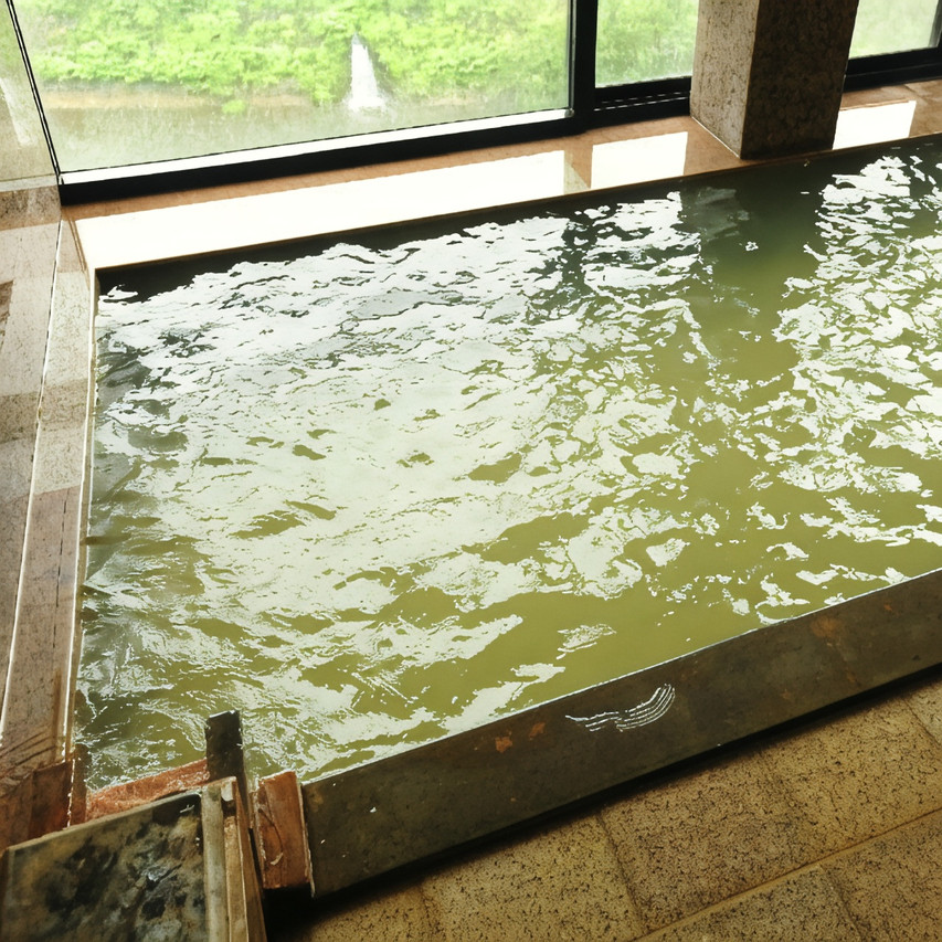 A bath beside a large window overlooking water.