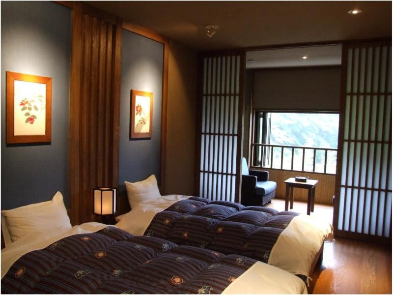Guest room with beds and balcony view.
