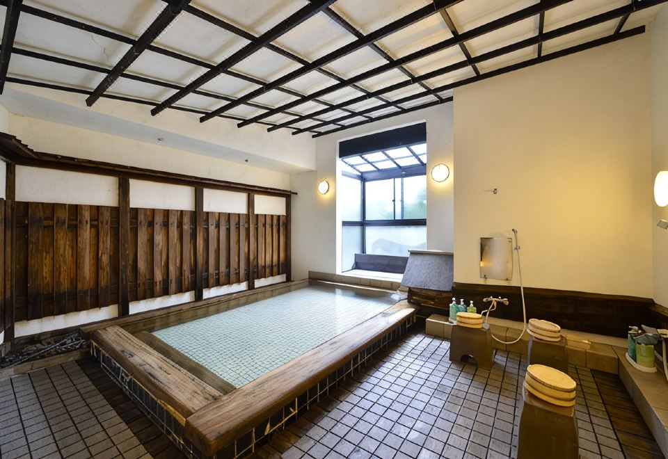 A tiled indoor bathing area with a large pool.