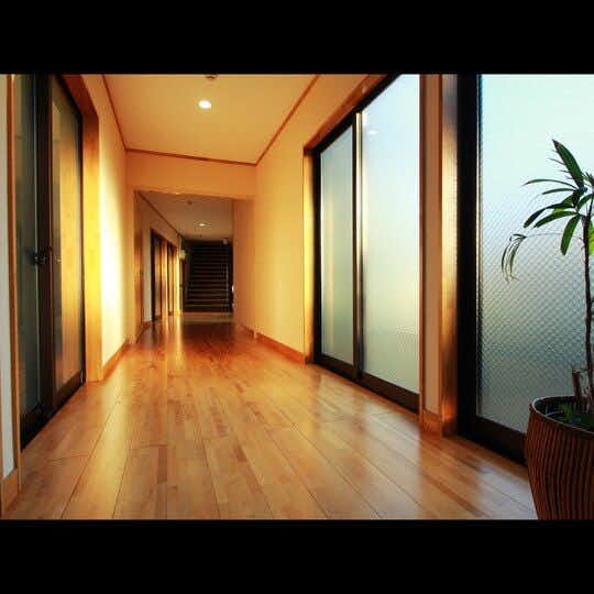 Yugawa Onsen Izumiya Ryokan <Fukushima Prefecture> with a polished timber corridor lined with frosted glass doors.