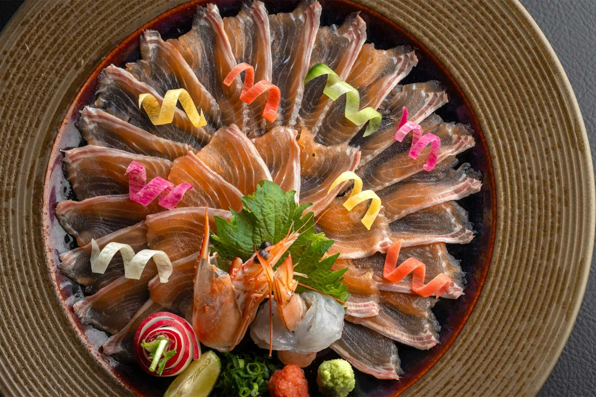 Bettei Tateshina Kaorukaze Circular ceramic bowl with arranged sliced seafood, green herb garnish in center