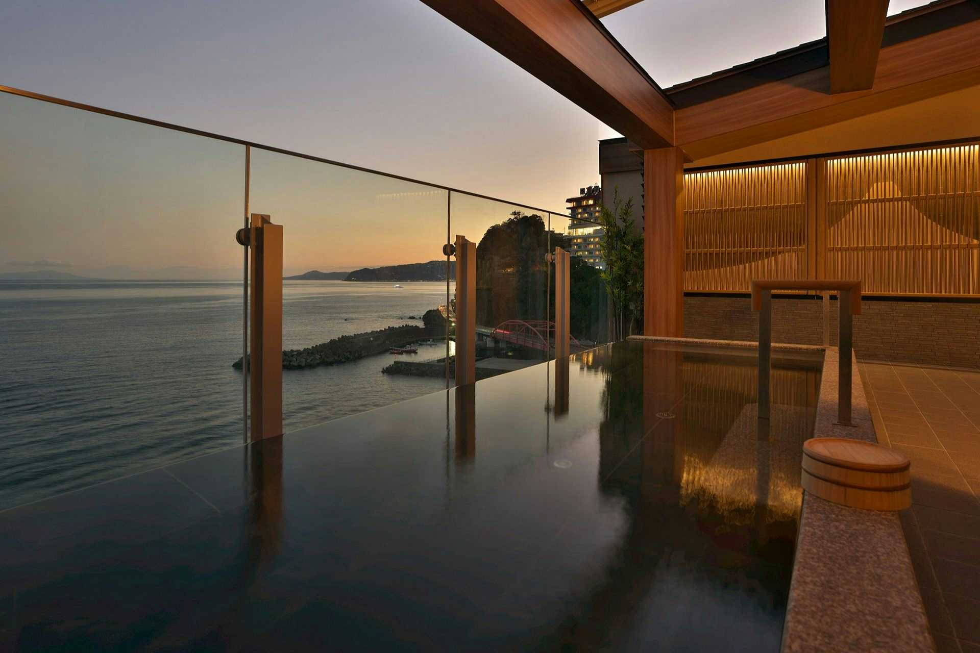 Izu-san Onsen Hotel New Sagamiya with an infinity-style mineral bath reflecting the morning sea.