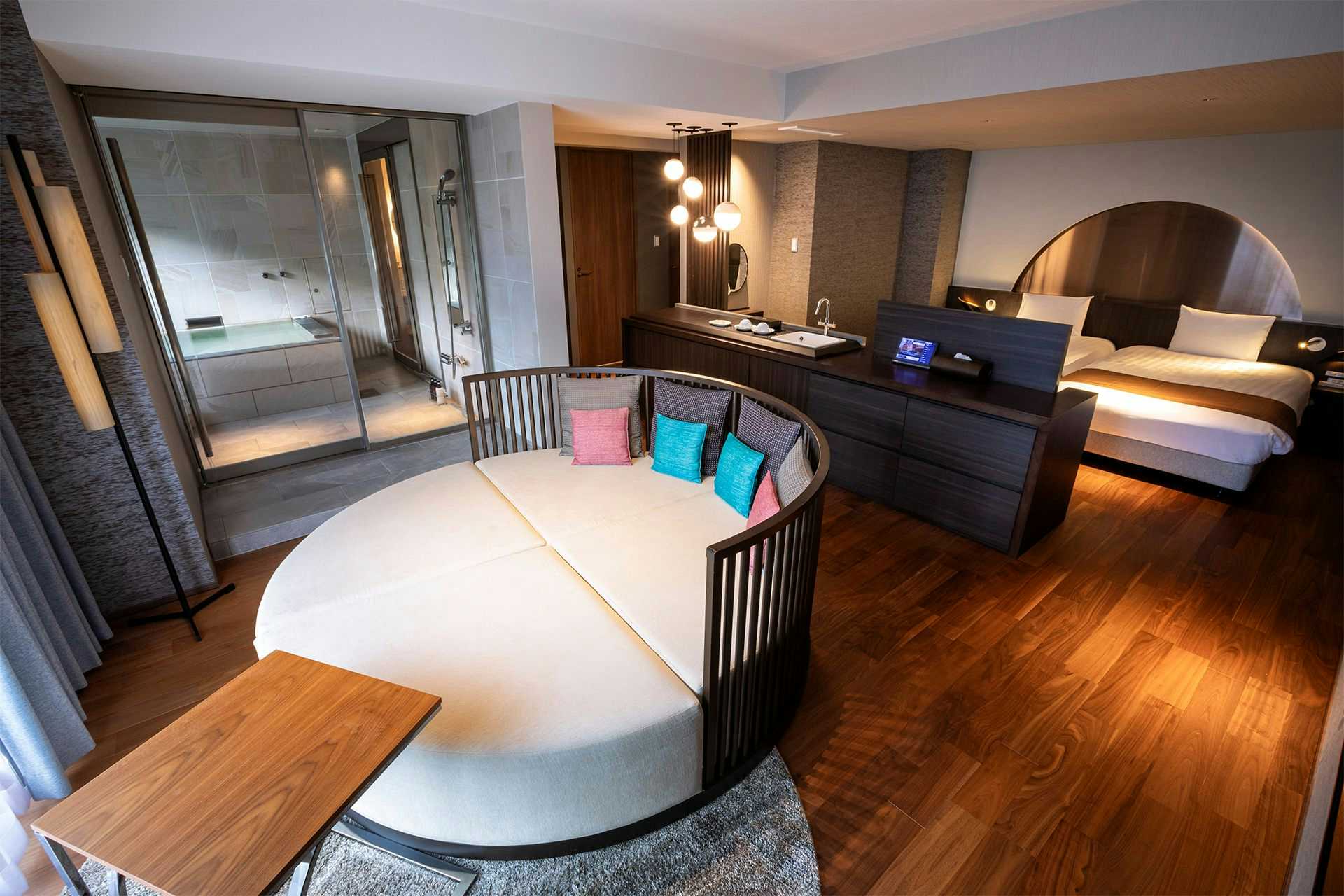 Shogetsu Grand Hotel with a modern guest room with round bed and dark timber.