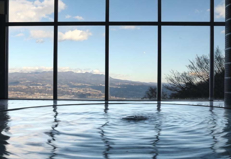 An indoor pool overlooking a mountain landscape.
