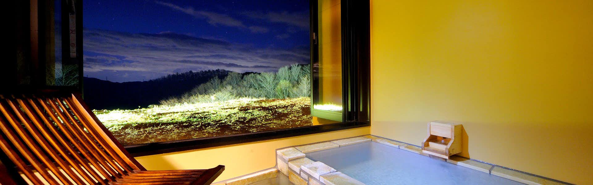 Ryuten Betsutei Kanzan Chogetsu Mountain landscape view through large window with geometric wood slatted screen casting shadow patterns at dusk