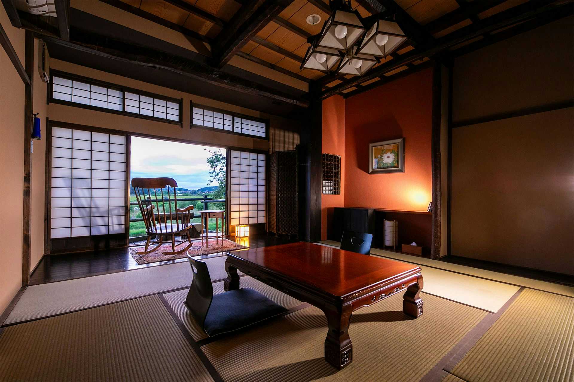 Isamikan a tatami room with a low table and wooden rocking chair.