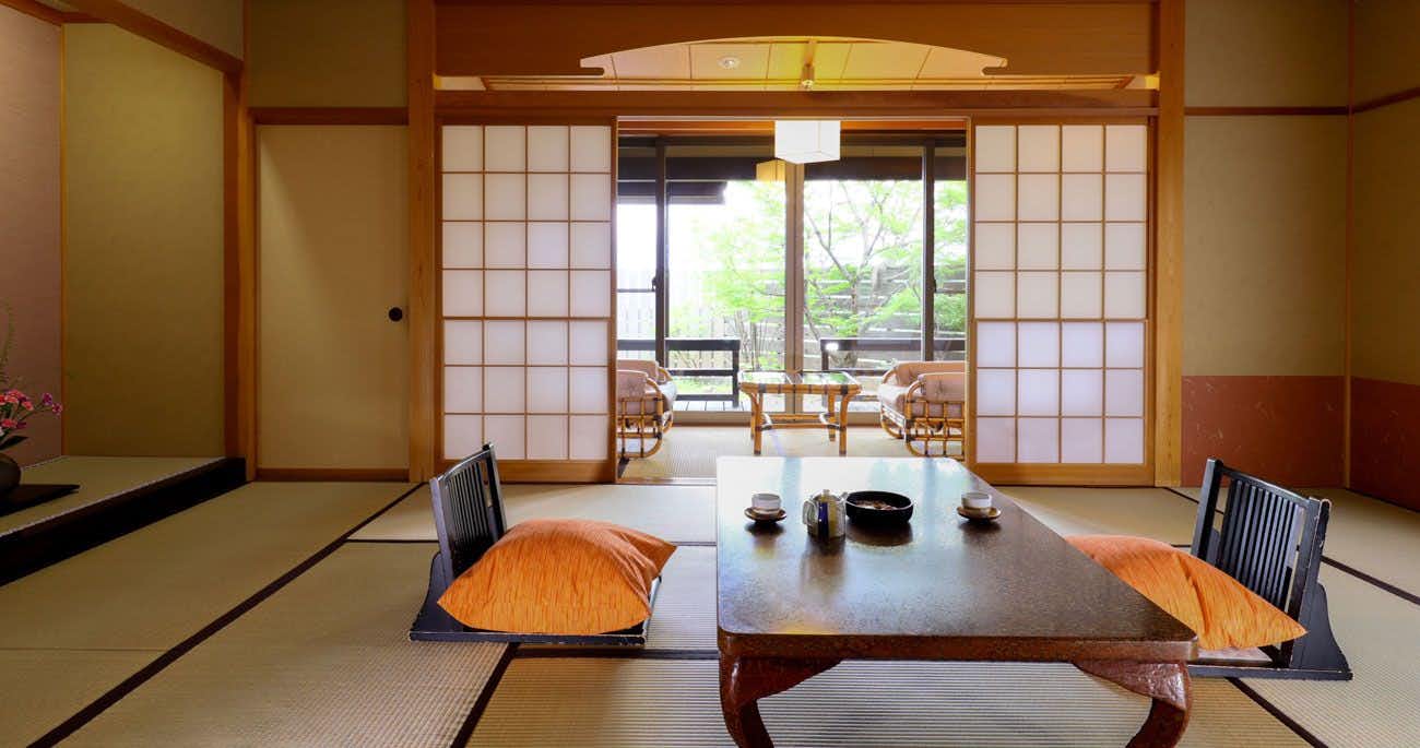 Hayataro Onsen Nagomi no Yuyado Nakayama with a calm tatami room opening toward broad garden windows.