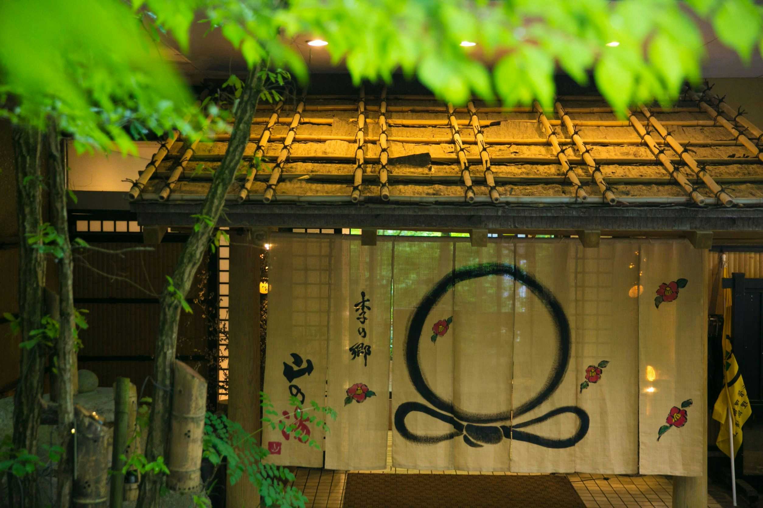 Kinosato Yama no Yu with a rustic bath entrance beneath a weathered tile roof.