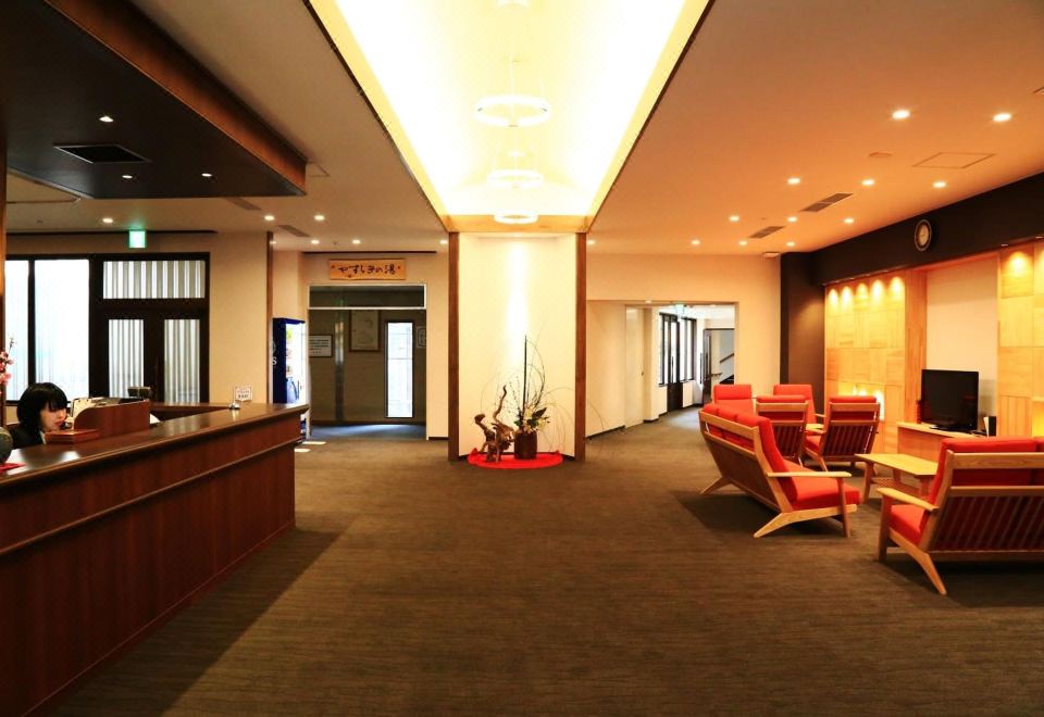 A hotel reception lounge with seating and a front desk.