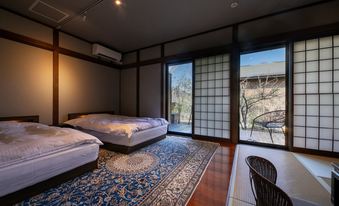 Twin-bed room with shoji panels and sliding doors opening toward a garden.