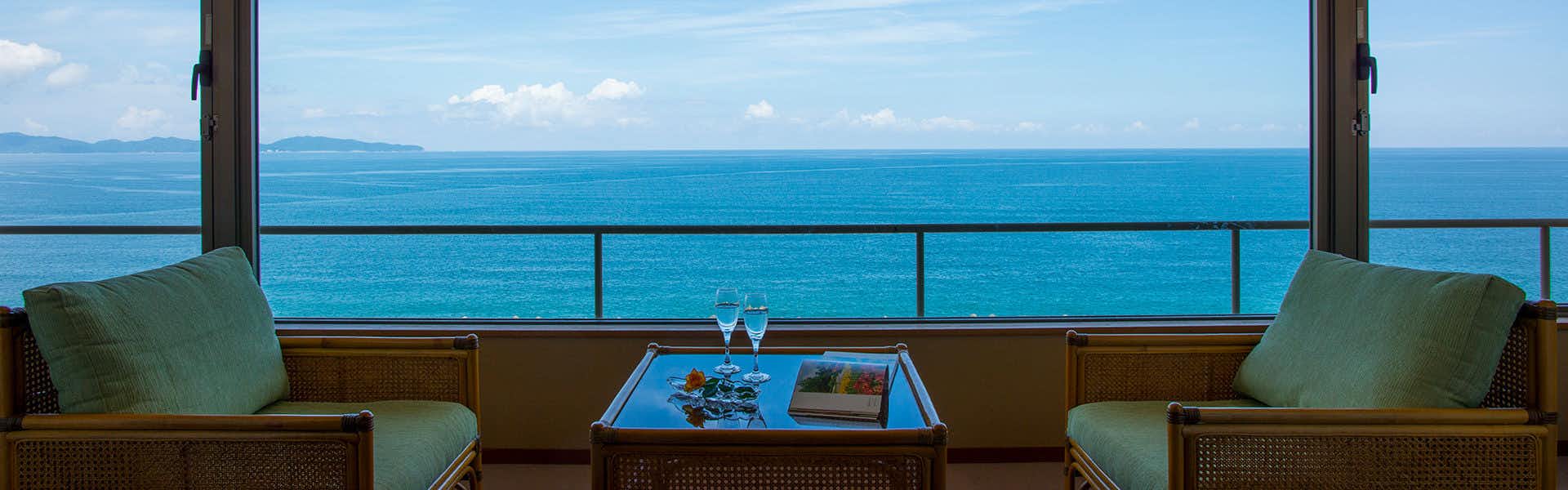 Seaside Inn Kaike Kikunoya with a panoramic lounge overlooking calm blue coastal water.