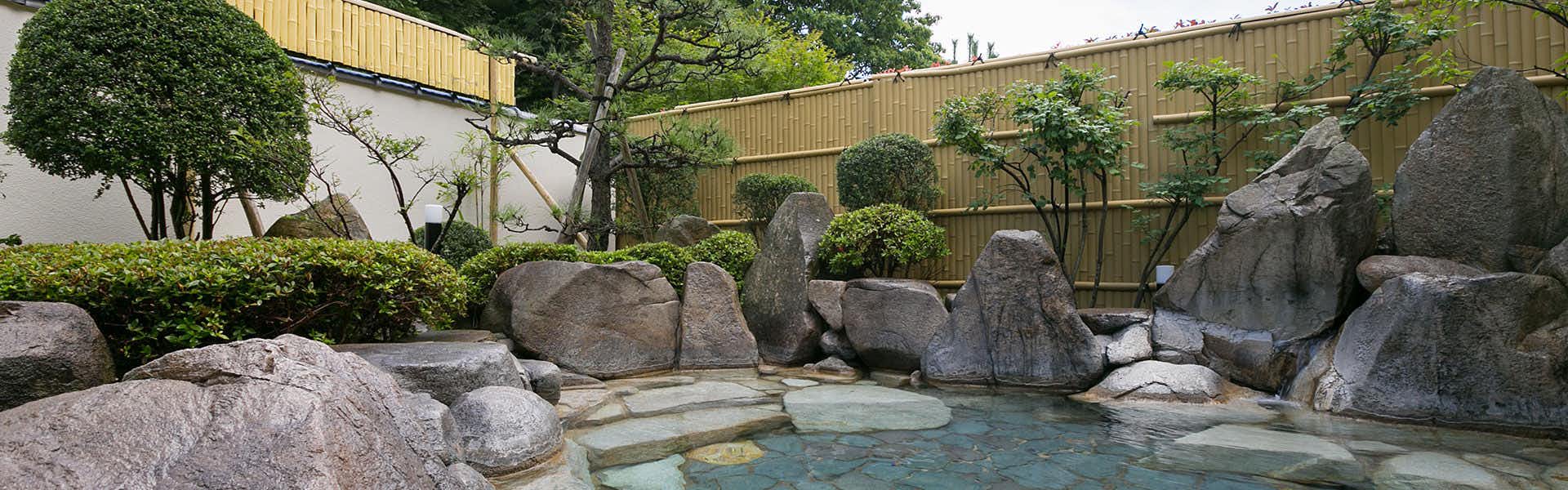 Sahimeno Inn of the Four Seasons with an outdoor rock bath set in a clipped garden.