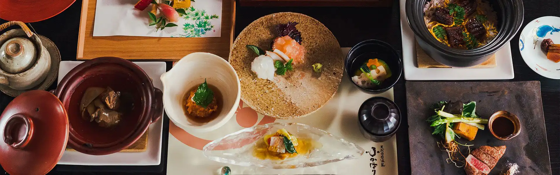 Fukahori-tei with this scene, where its dinner is arranged across dark bowls, stoneware plates and small dishes.