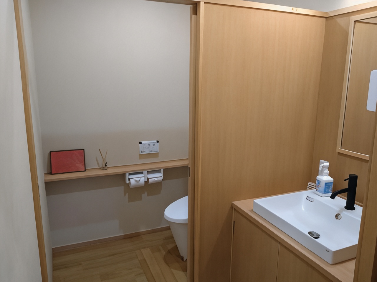 Compact washroom with a toilet and sink.
