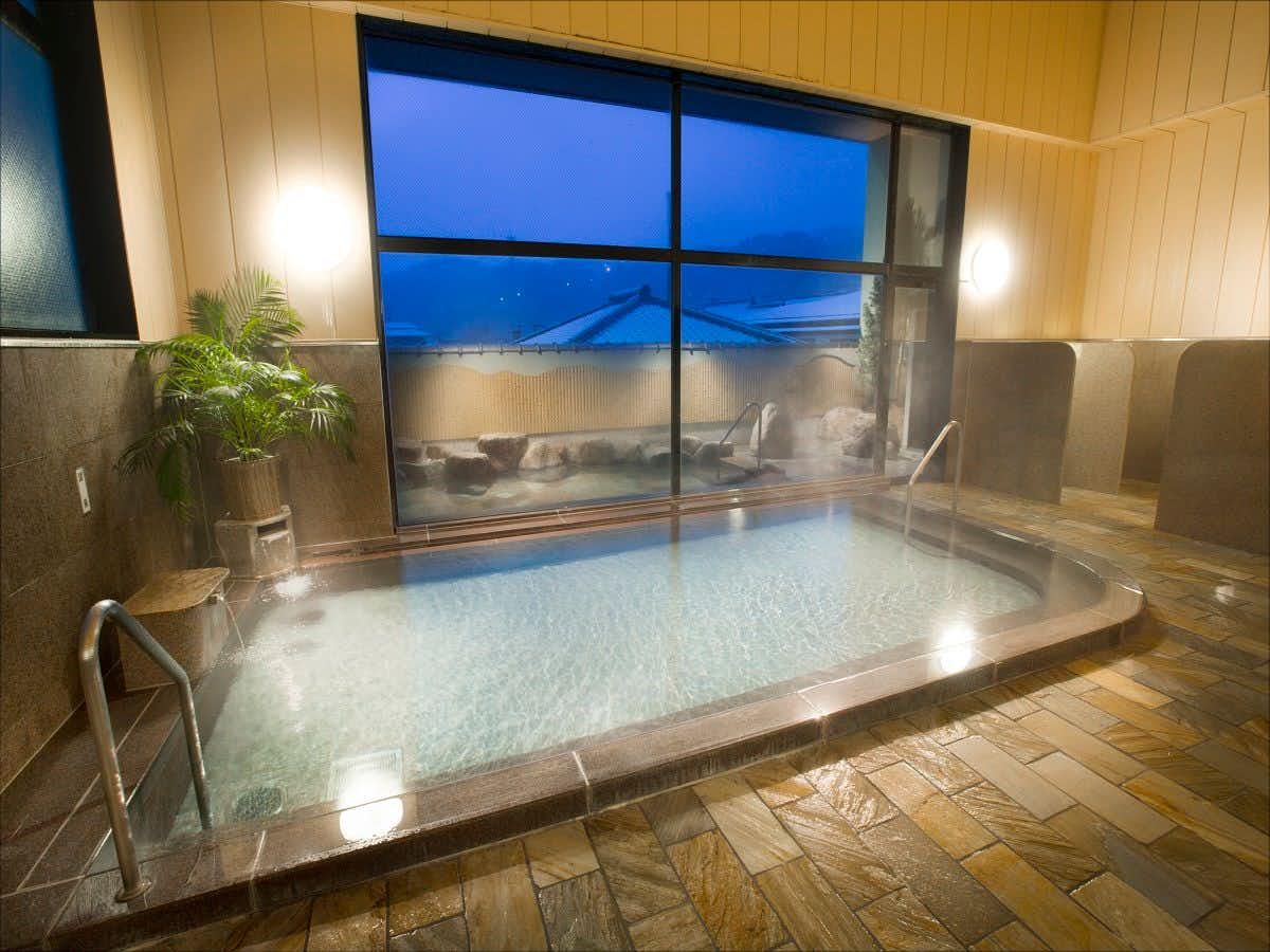 Healing Inn Seifu-en with a bright indoor bath overlooking the mountain town.