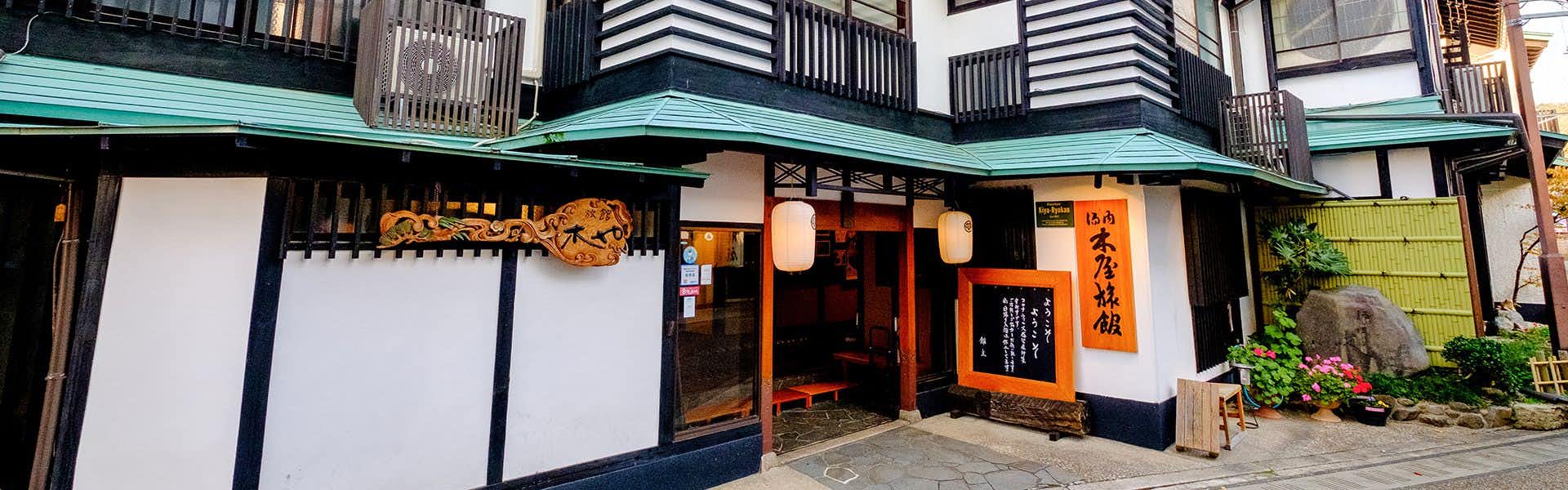 Kiya Ryokan, a Registered Tangible Cultural Property Inn with a close street view of the timber entrance facade.