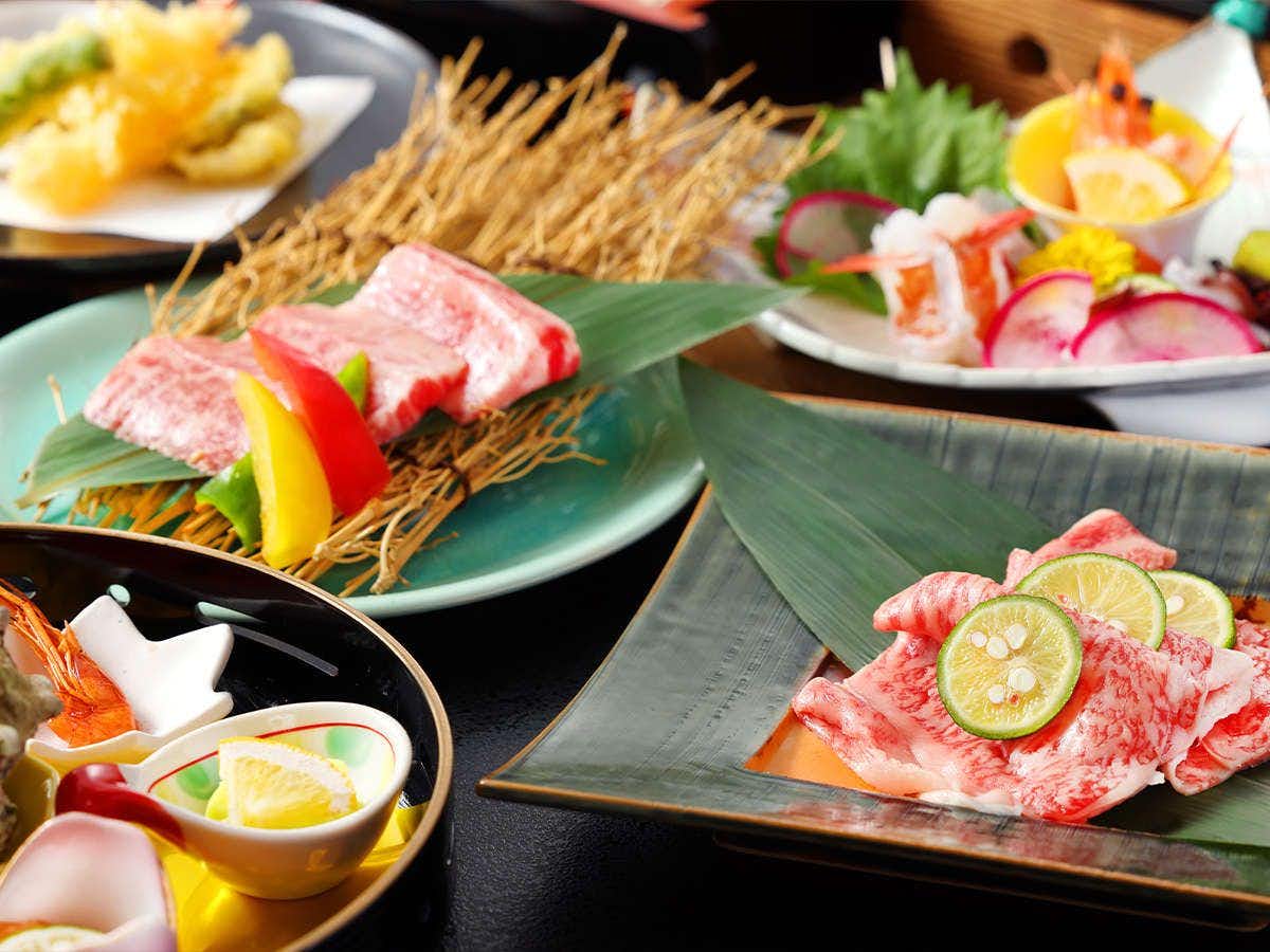 Ikedaya Kajikaen Sliced meat on black round plates and green leaf-shaped serving dishes, lemon slice garnish, straw placemats, yellow flower decoration, multiple place settings.