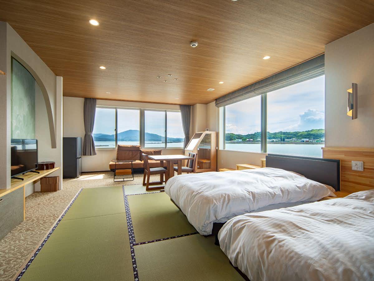 Amakusa Hamabe no Yado Minami with a modern twin bedroom overlooking calm coastal water.