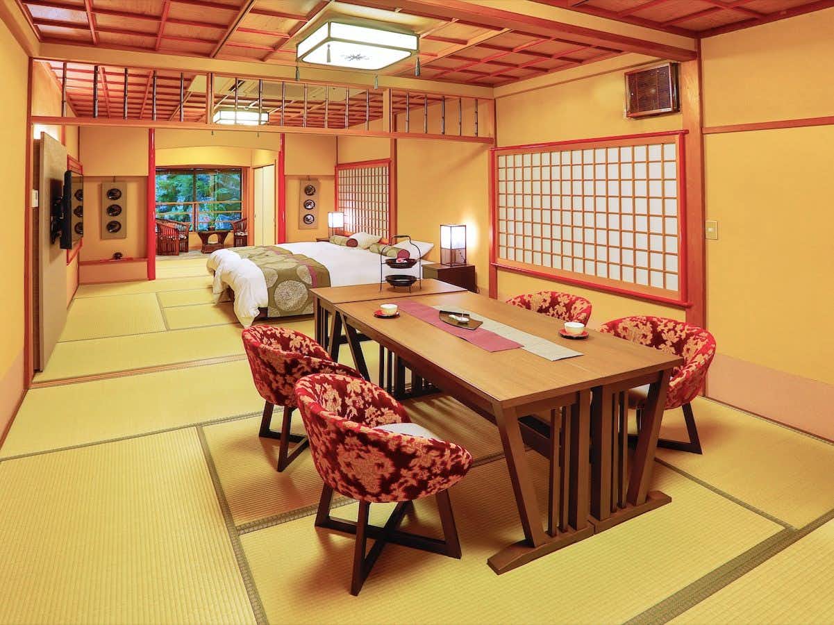Kinosaki Yumekoyado Tenbouen with a colorful tatami room with patterned chairs and bedding.