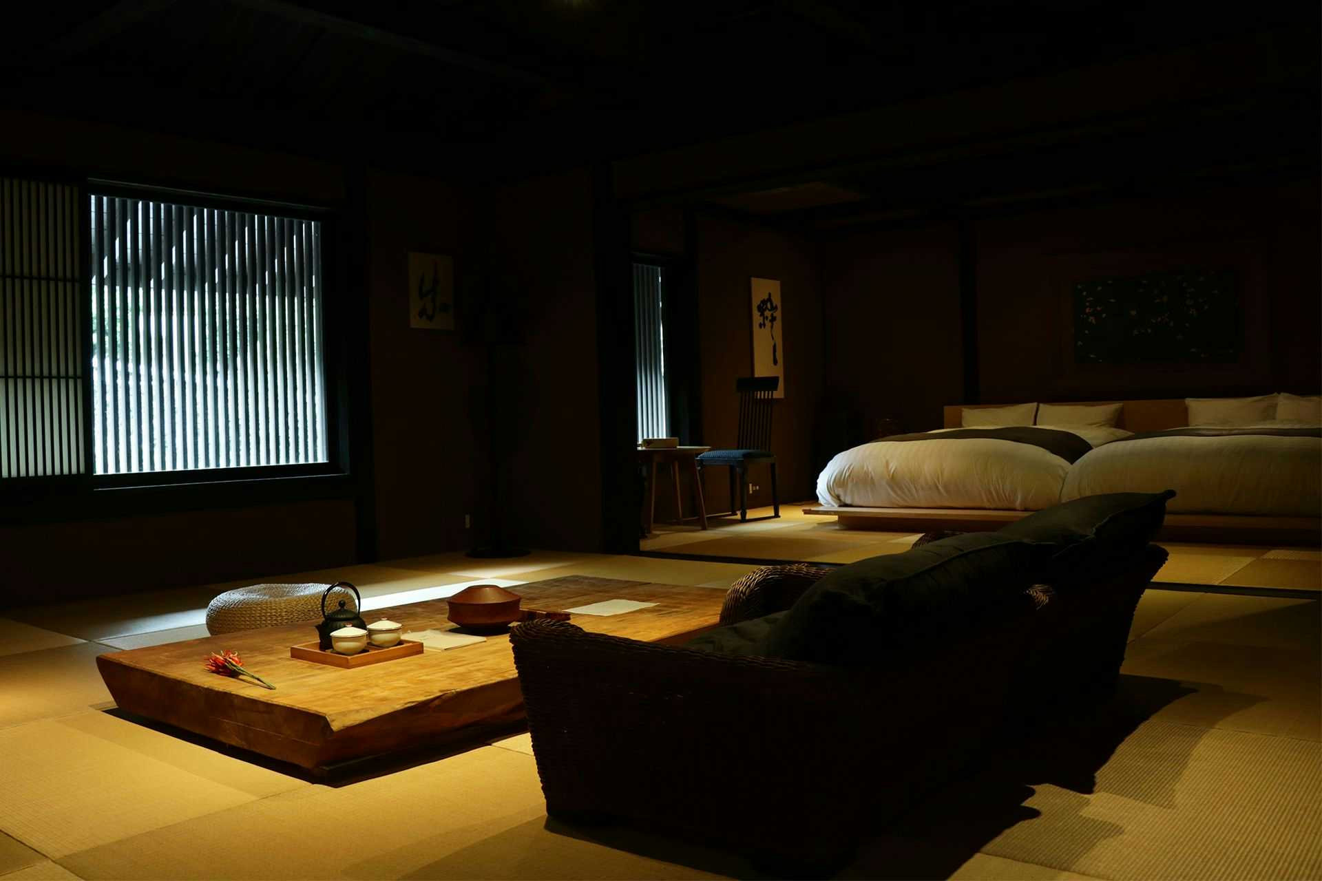 Yunotsuru guest place Tsurunoya with a dark modern lounge with low table and platform bed.