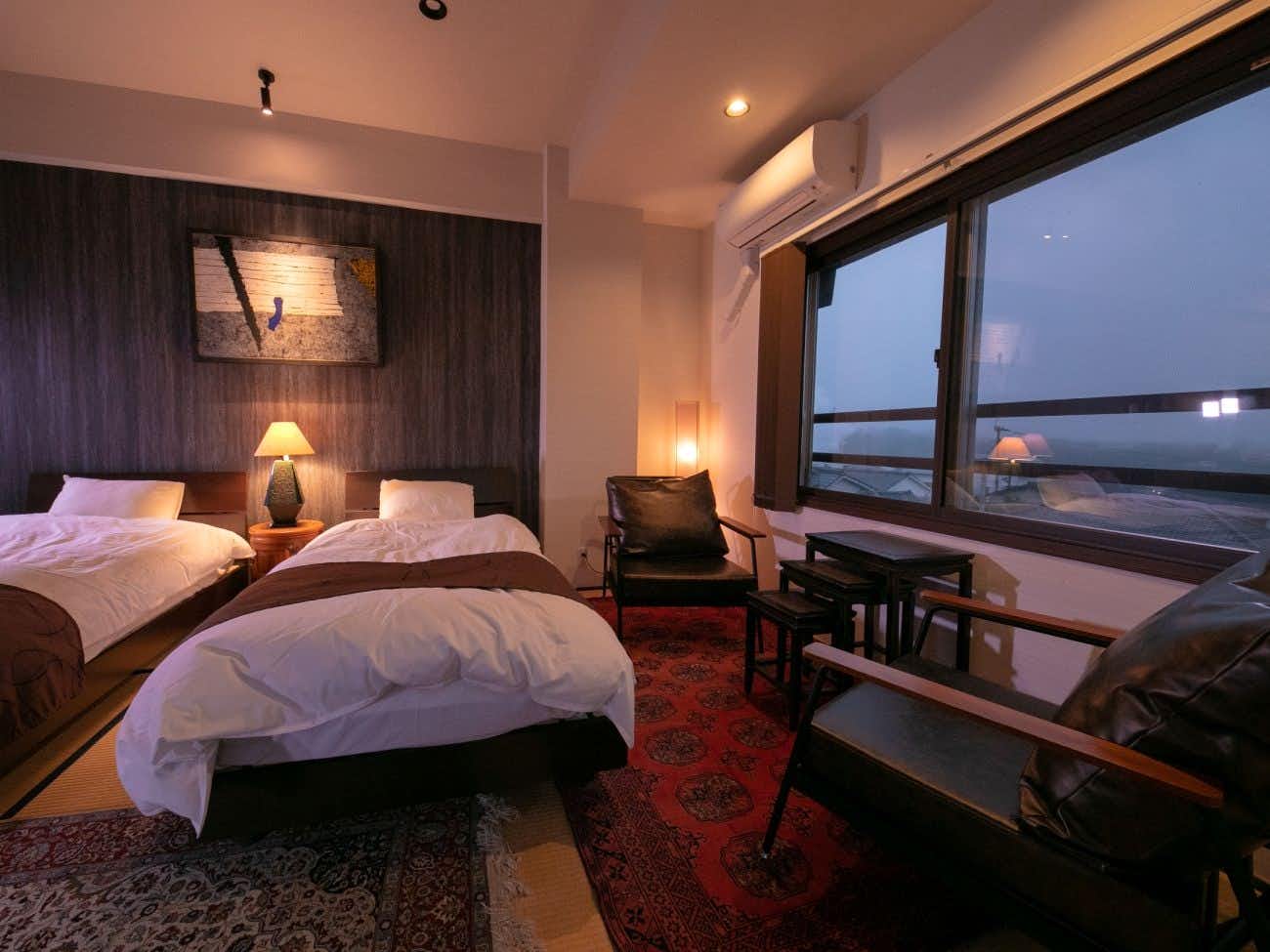 Beppu Kannawa Kunisakisou with a modern twin bedroom overlooking lights at dusk.