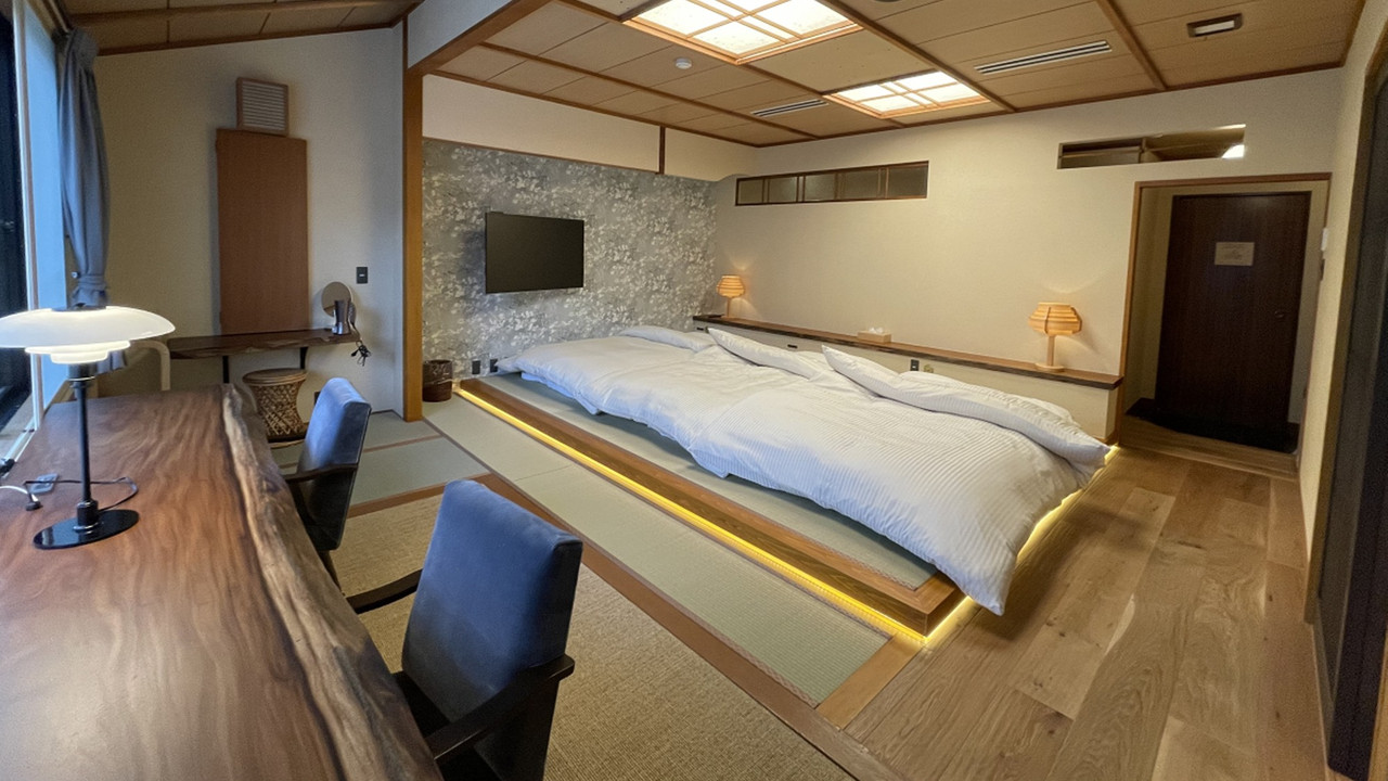 A bedroom with a large bed and seating.