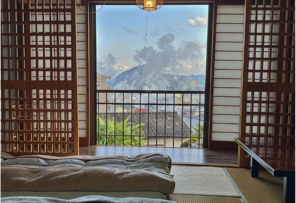 Futon bedding beside a balcony with a mountain view.
