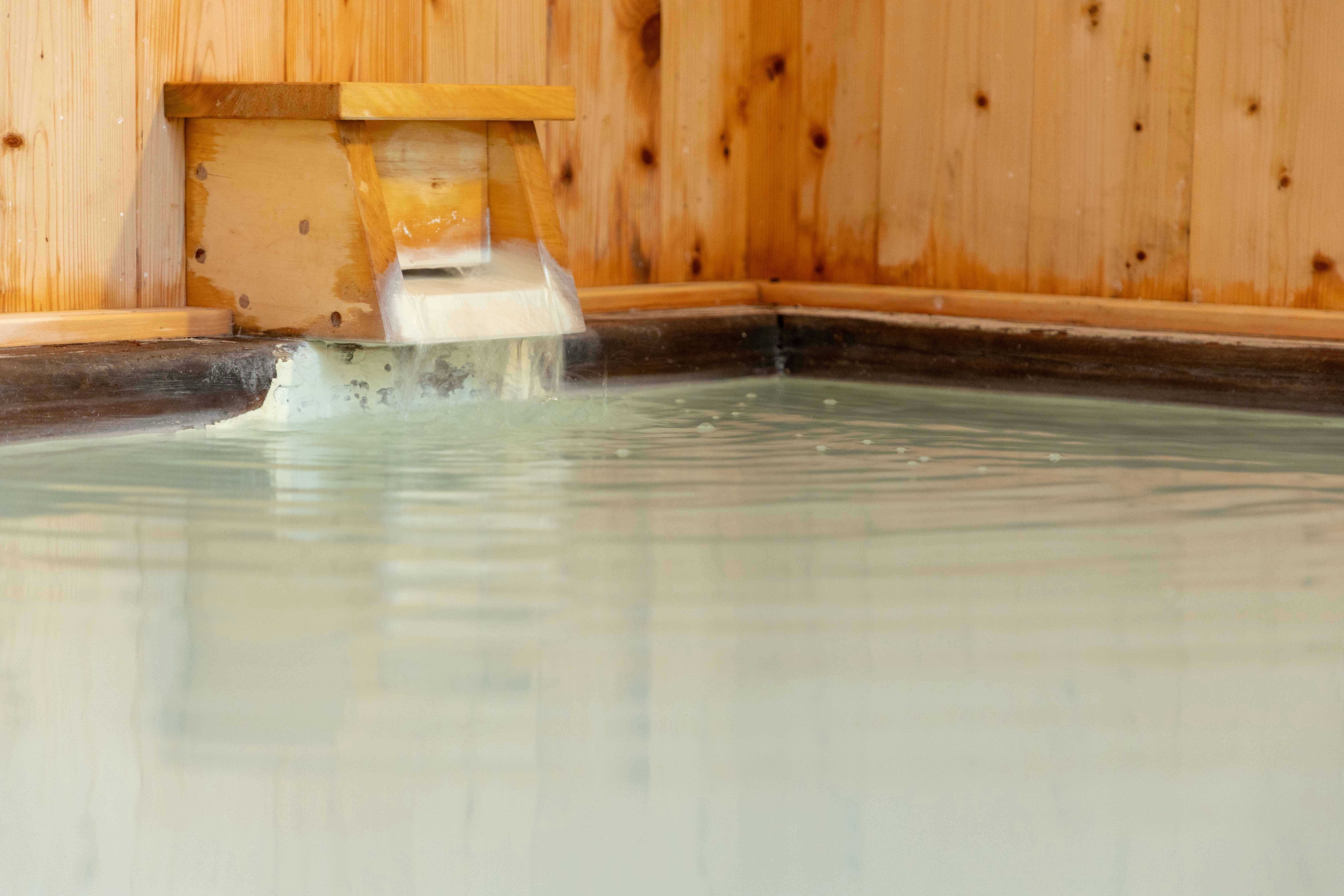 Onsen Ryokan KODAMA with a private timber bath filled with pale mineral water.