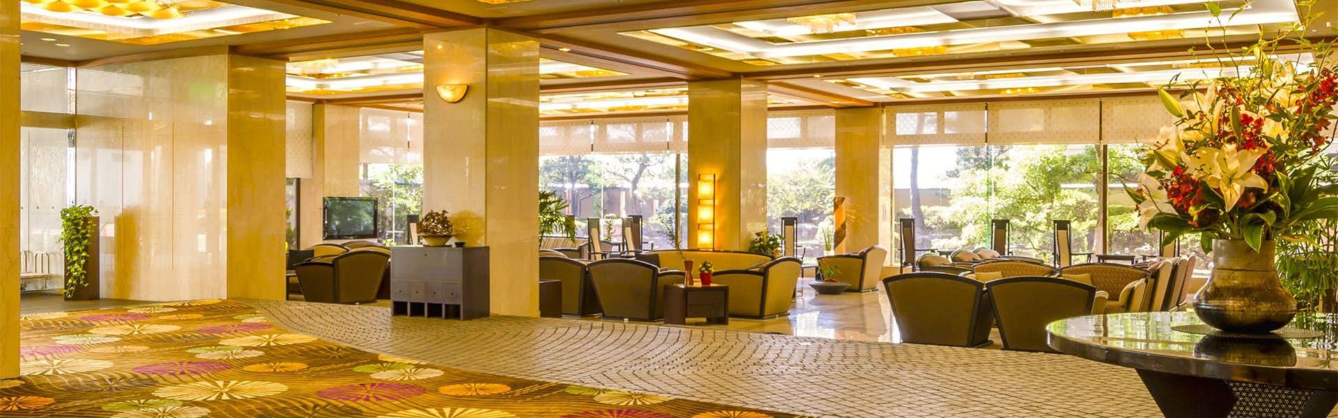Awara Onsen Matsuyama Sensen with a bright lobby filled with sofas and large flower arrangement.